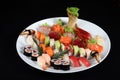 Sushi and sashimi mixed on round white plate Royalty Free Stock Photo