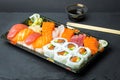 Sushi and Sashimi rolls on a black stone slatter. Fresh made Sushi set with salmon, prawns, wasabi and ginger. Traditional Japanes Royalty Free Stock Photo