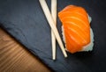 Sushi and Sashimi rolls on a black stone slatter. Fresh made Sushi set with salmon, prawns, wasabi and ginger. Traditional Japanes Royalty Free Stock Photo