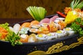 Sushi sashimi set in a wooden boat on a brown Royalty Free Stock Photo