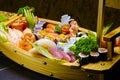 Sushi sashimi set in a wooden boat on a brown Royalty Free Stock Photo