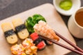 Sushi set with chop sticks, wasabi served on wooden slate, selective focus - Sushi is food originating in Japan, consisting of co Royalty Free Stock Photo