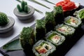 Green sushi set with chuka served on black clay plate with soy sauce and chopsticks, top view. Delicious traditional Royalty Free Stock Photo