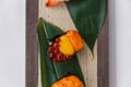 Sushi Set Close-up on Quail Egg Yolk Served on Leaf on Stone Plate.