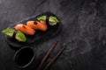 Sushi set on dark stone slate background. Decorated sashimi nigiri with salmon and avocado. Close up, copy space Royalty Free Stock Photo