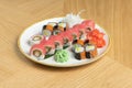 Sushi set of different rolls with tuna, salmon, shrimp, ginger, daikon radish, and wasabi.