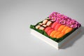 Sushi set with flowers in gift box on grey background. Creative chocolate candy box. Date, Valentines Day, Mother`s day