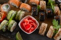 Sushi set food photo. Rolls served on brown wooden and slate plate. Close up view of pickled ginger Royalty Free Stock Photo