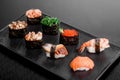 Gunkan and sushi set with salmon, eel, shrimp, chukka and chicken on a black plate on a dark background. . close up. Royalty Free Stock Photo