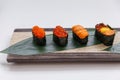 Sushi Set Include Tobiko, Ikura, Sea Urchin and Ikura, Urchin and Quail Egg Yolk Served on Leaf on Stone Plate Royalty Free Stock Photo
