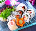 Sushi set with maki rolls, wasabi and pickled ginger. Uramaki sushi on a blue, glass plate. Royalty Free Stock Photo