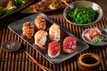 Sushi Set nigiri, Gyozas dumplings and wakame salad in ceramic plates with soy sauce and chopsticks on bamboo mat. Copy space. Royalty Free Stock Photo