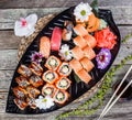 Sushi Set nigiri and sushi rolls decorated with flowers on bamboo background. Japanese cuisine. Top view. Royalty Free Stock Photo