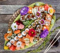 Sushi Set nigiri and sushi rolls decorated with flowers on bamboo background. Japanese cuisine. Royalty Free Stock Photo