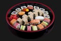 Sushi Set nigiri, rolls and sashimi served in traditional Japan black Sushioke round plate. On dark background Royalty Free Stock Photo