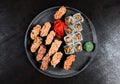Sushi Set nigiri rolls and sashimi served in traditional Japan black Sushioke round plate with wasabi and ginger on dark Royalty Free Stock Photo
