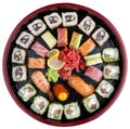 Sushi Set nigiri, rolls and sashimi served in traditional Japan black Sushioke round plate. On white background Royalty Free Stock Photo