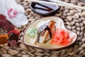 Sushi Set nigiri and sushi rolls decorated with flowers on bamboo background. Royalty Free Stock Photo