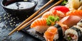 Sushi Set nigiri and sushi rolls on serving stone with soy sauce and chopsticks over black stone texture background Royalty Free Stock Photo