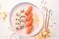 Sushi set on a pink plate on bright background. Philadelphia maki roll and salmon sashimi nigiri. Festive mood Royalty Free Stock Photo