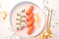 Sushi set on a pink plate on bright background. Philadelphia maki roll and salmon sashimi nigiri. Festive mood Royalty Free Stock Photo