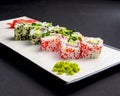 Sushi set, sushi rolls with cream cheese and caviar served on a white plate over black background Royalty Free Stock Photo