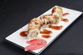 Sushi set, sushi rolls with cream cheese and eel served on a white plate over black background Royalty Free Stock Photo
