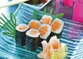 Sushi set. Salmon maki rolls and pickled ginger on a blue, glass plate. Japanese delicacy. Royalty Free Stock Photo