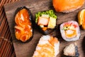 Sushi Set sashimi and sushi rolls served on wood slate.