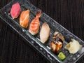 Sushi set with seafood, salmon, shrimp, tuna, smoked eel on a glass plate, close up photo on dark background Royalty Free Stock Photo