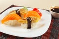 Sushi set and soy sauce on black and red bamboo mat close up. Royalty Free Stock Photo