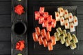 Sushi set and soy sauce on a black wooden table, top view. Japanese food. Menu.