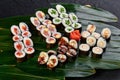 sushi set with tuna, salmon, shrimp, eel and color cucumber lies on a background of green bamboo leaves