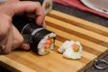 Hands with knife and sushi on the wooden desk Royalty Free Stock Photo