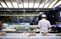 Sushi on a sliding rail and Japanese food chef in a Japanese restaurant in a shopping mall at Sukhumvit road Bangkok Thailand