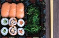 Sushi take-away tray detail with maki, nigiri and wakame. Maki. Sashimi. Salmon. Tuna. Wakame. Chopsticks. Take-away japanese food Royalty Free Stock Photo