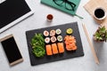 Sushi takeaway at work desk with laptop overhead. Eating sushi for lunch break at office, lunch meal at work, top view Royalty Free Stock Photo