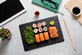 Sushi takeaway at work desk with laptop overhead. Eating sushi for lunch break at office, lunch meal at work, top view Royalty Free Stock Photo