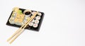 Sushi to go in a black takeaway box with wooden chopsticks on white background Royalty Free Stock Photo