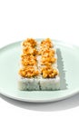 Sushi topped burnt shrimp tartare. Maki sushi with shrimp and spicy sauce on ceramic plate Baked maki roll topped shrimp tartare