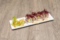 Sushi uramaki roll with avocado and surimi, nori seaweed, sauces and tengusa