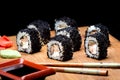 Sushi zuko maki with shrimp, cheese, cucumber, and black masago caviar. Sushi prepared for eating on a wooden board Royalty Free Stock Photo