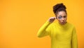 Suspecting afro-american woman looking thorough magnifying glass, inspection Royalty Free Stock Photo