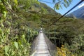 Suspended bridge hanging above the Santa Teresa River in green lush valley. Trek to Machu Picchu, Peru Royalty Free Stock Photo