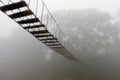 Suspended bridge in the misty forest Royalty Free Stock Photo