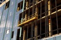 Suspended construction craddle for glazing a facade of a commercial property at sunset. Engineering urban background