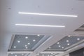 Suspended and grid ceiling with halogen spots lamps and drywall construction in empty room in store or house. Stretch ceiling