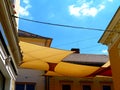 Suspended sun protection awning or tent of cotton fabric stretched over street in old European town