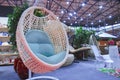 Suspended white rattan garden chair with cushions