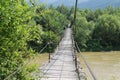 Suspended wooden bridge across Schodnica river in Carpathians